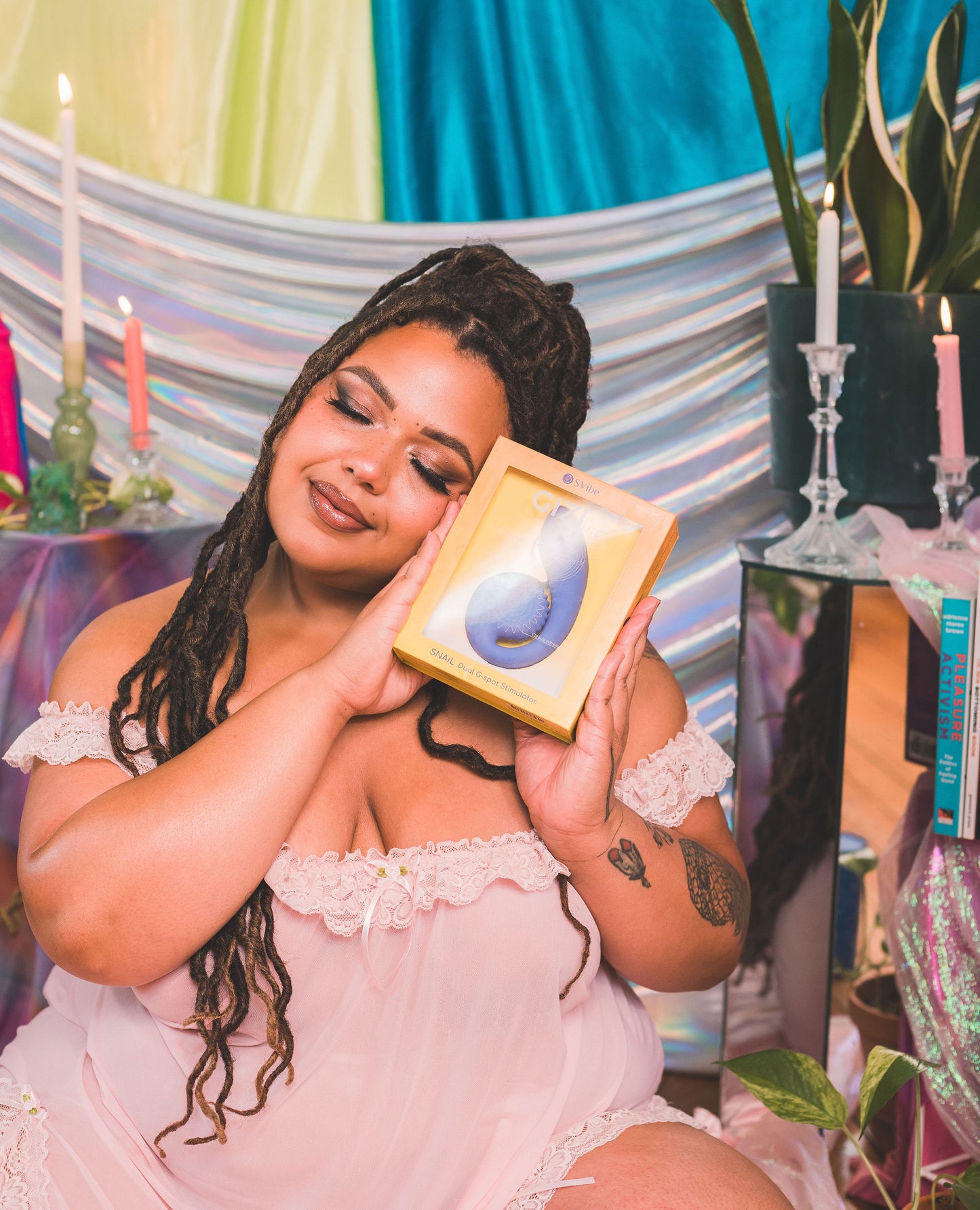 Woman holding Snail Vibe SVibe GIZI Lite in front of a colorful, decorative background