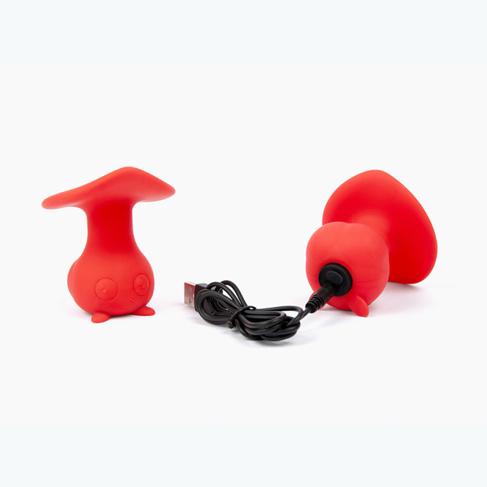 Red silicone vibrator with USB cable on a white background