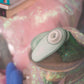 Close-up of a green and gray Womanizer Liberty 2 with a pink glittery background