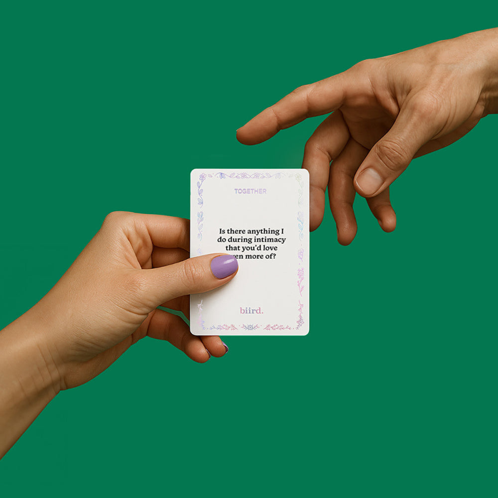 Two hands holding a card with text against a green background