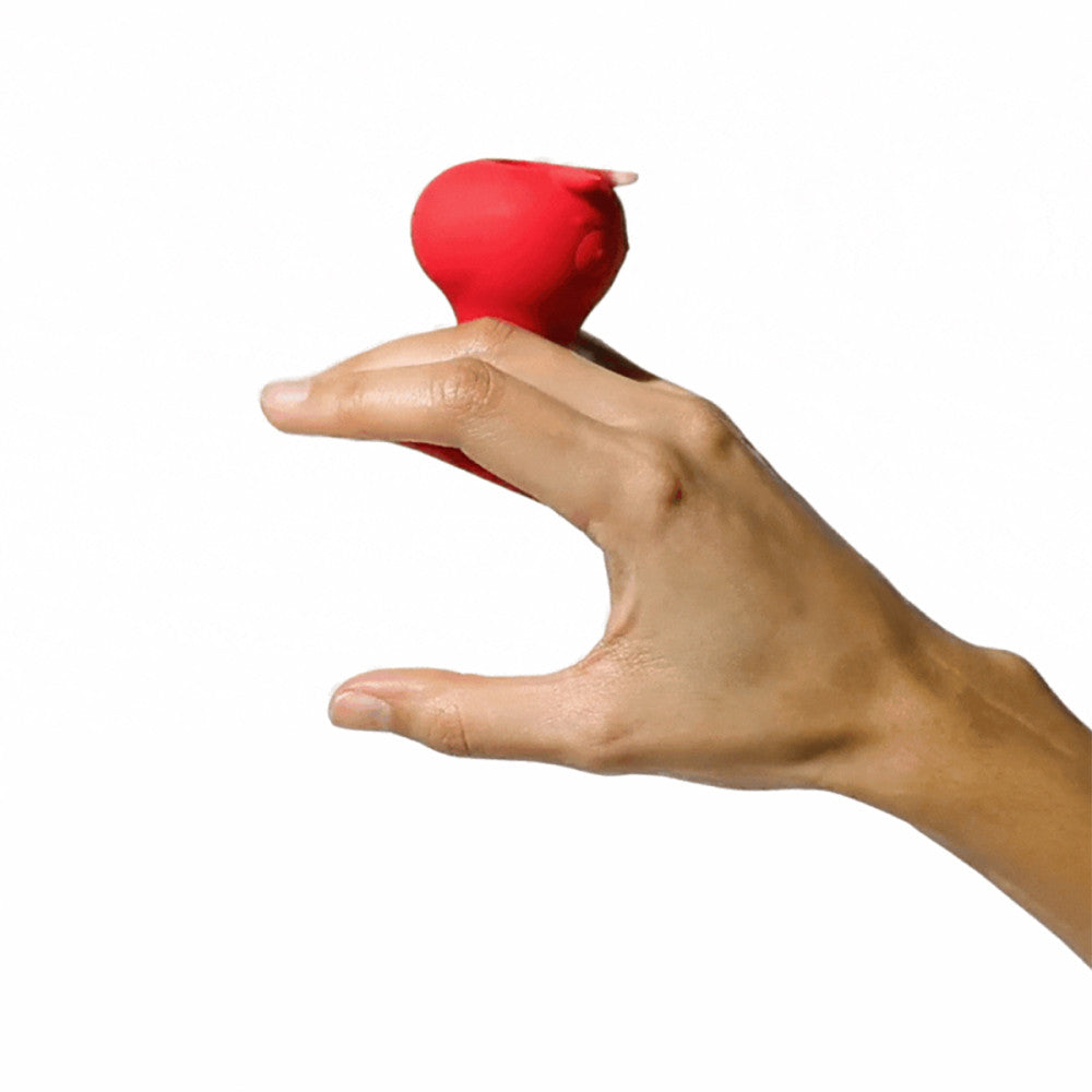 Hand holding a red vibrator against a white background