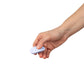 Hand holding Dame Lay Panty Vibrator remote control on a white background