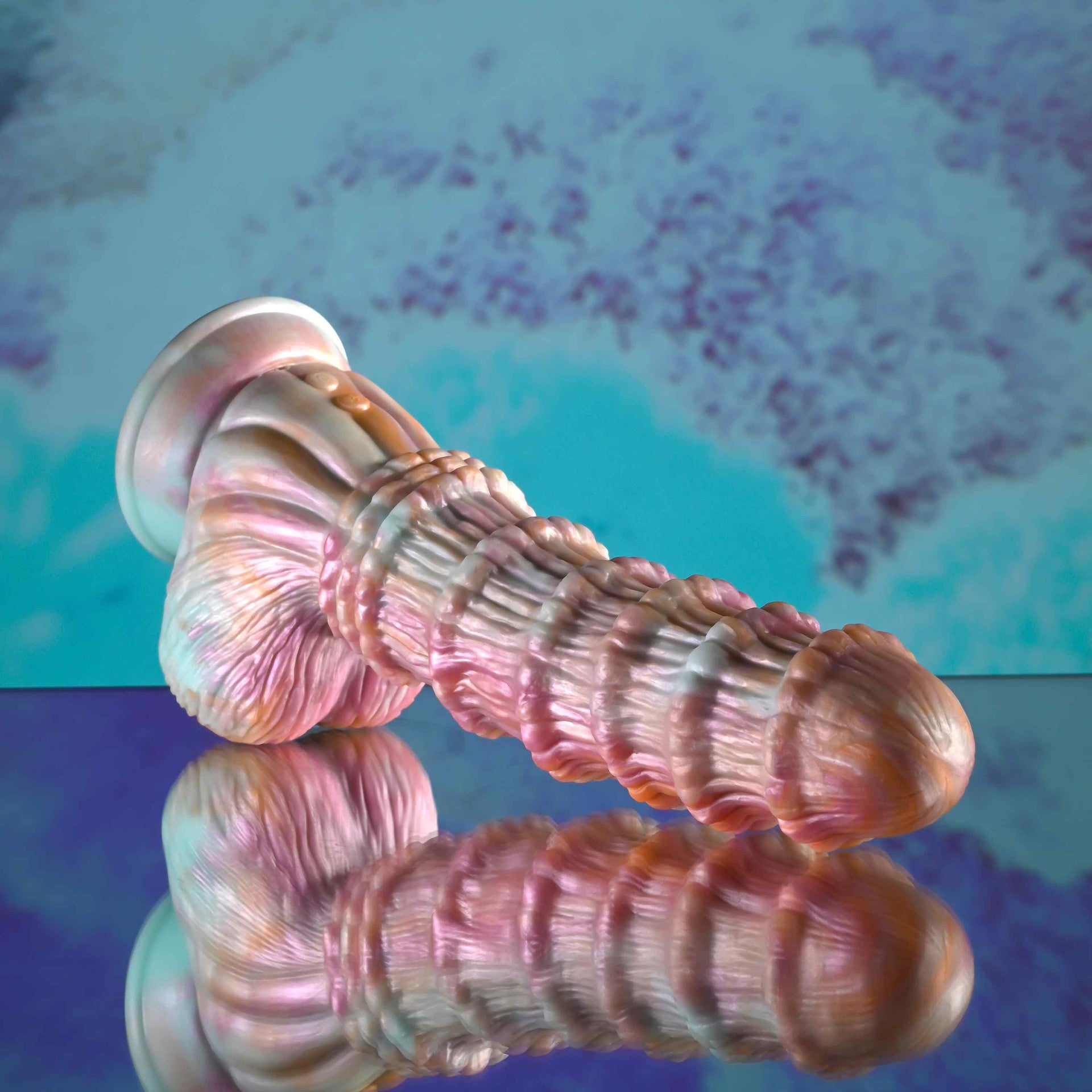 Decorative Evolved Fantasy Ridged Dildo with a textured surface on a reflective blue and purple background