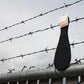 Tantus Pelt Silicone Paddle with a brand logo on a barbed wire fence