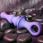 Purple Gender X Ring Pop sex toy on purple stones