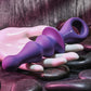 Purple and pink Gender X Ring Pop vibrator on a textured surface