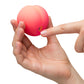 Hand holding Romp Pink Peach Vibrator against a white background