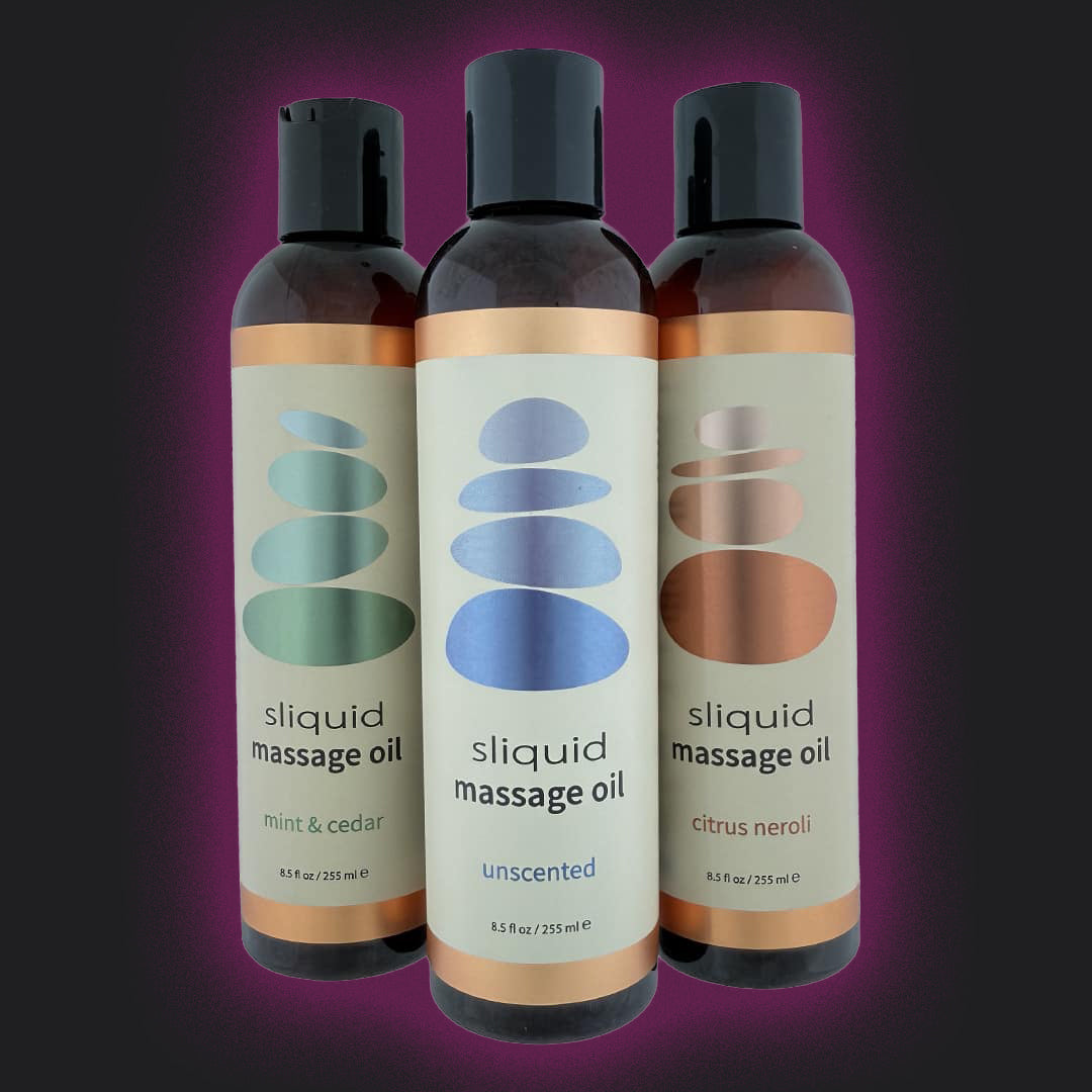 Three bottles of sliquid massage oil on a purple background