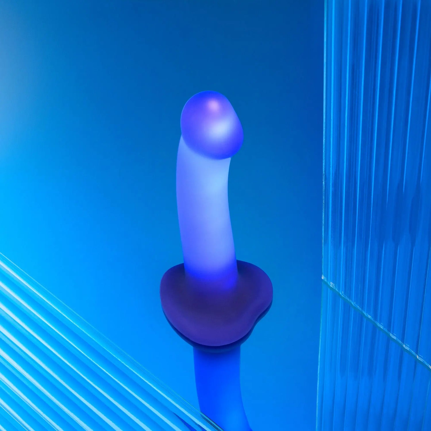 Blue and purple Strap-on-Me Glow-Led Dildo on a blue background