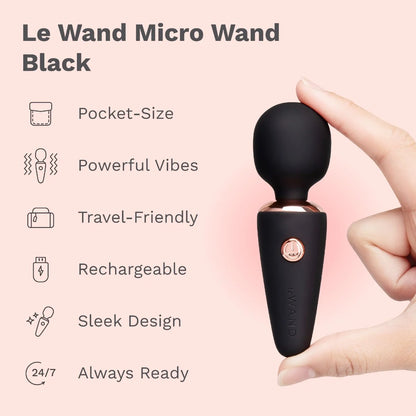Black Le Wand Micro Wand held by a hand with product features listed on a pink background